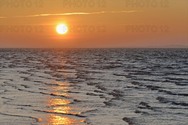 Sunrise on the beach with rising waves
