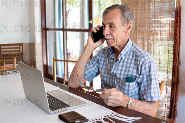 Portrait senior man using laptop for working at home