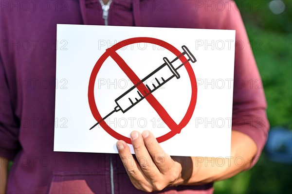 Anti vaccine demonstration sign with syringe drawing in red crossed out circle