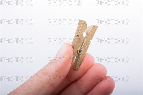 Hand holding a small wooden clothespin in hand