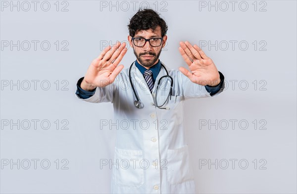 Doctor making a stop gesture with palms on isolated background. Young doctor making a stop gesture with his hands isolated