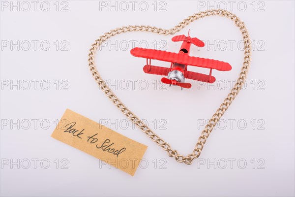 Chain forms a heart shape with a title back to school in it with a red model airplane
