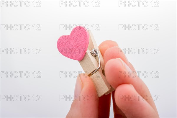 Heart shape icon attached to a clothespin in hand