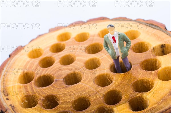 Little man figurine places on a wooden log