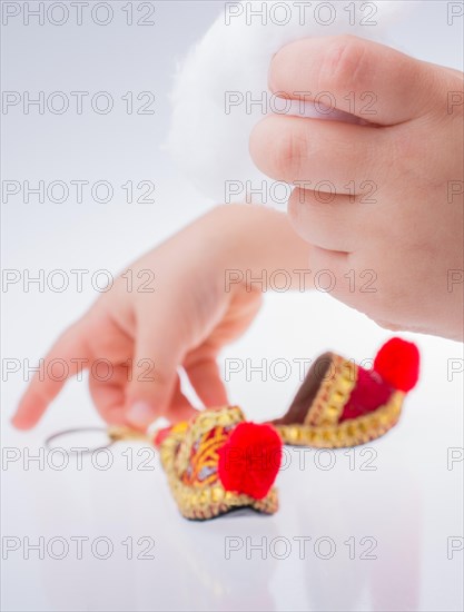 Traditional slippers in hand on white background