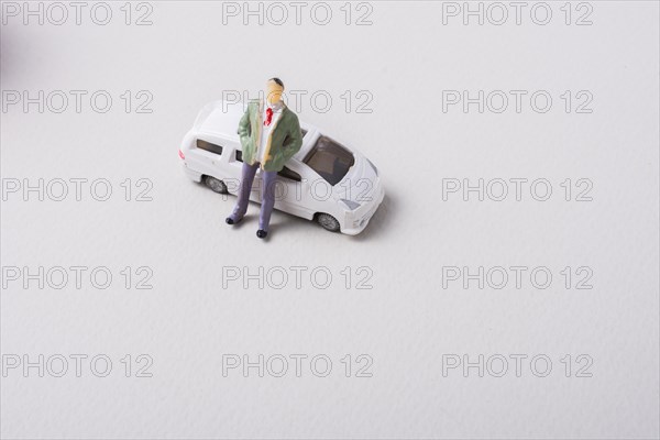 Tiny figurine of man before a miniature car