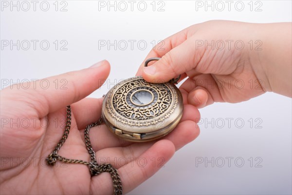 Retro style pocket watch in hand on white background