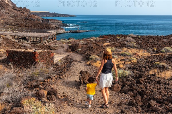 Mother and son on holiday on a path along the beach at Tacoron on El Hierro