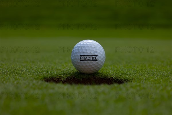 Golf Ball and Hole on Putting Green with Text Practice in Switzerland