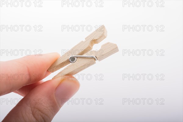 Hand holding a small wooden clothespin in hand