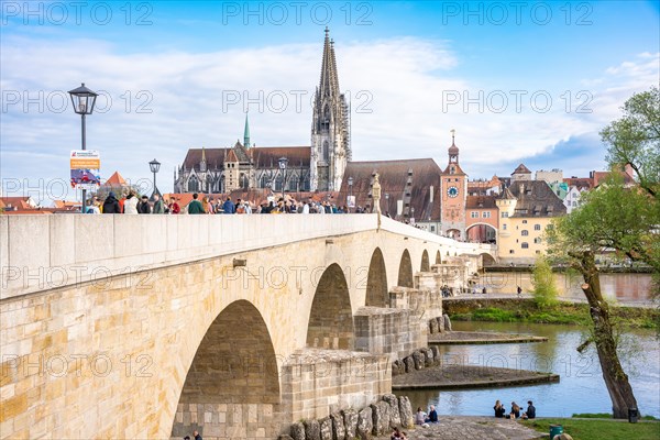 Bridge with many people and cathedral in the background