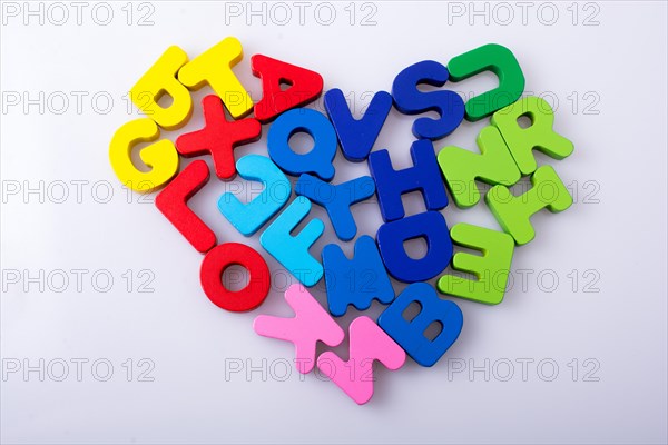 Colorful letter blocks shape heart on white background