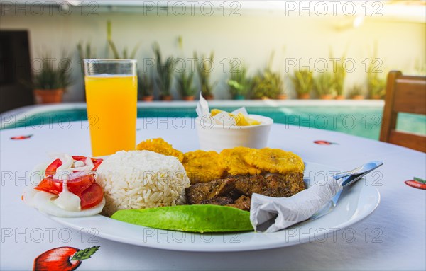 Traditional breakfast with orange juice near a swimming pool. Vacation breakfast near a swimming pool