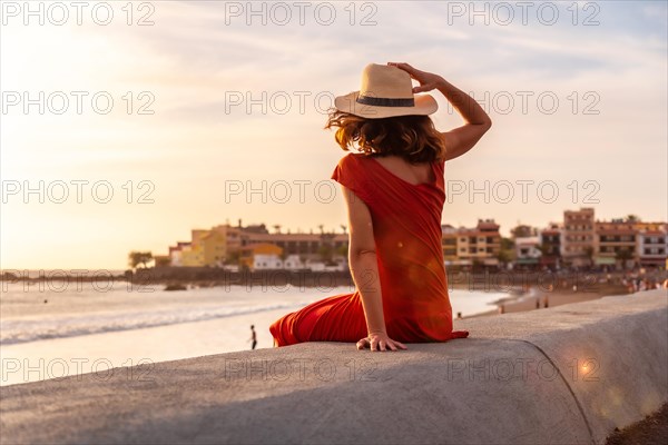 Tourist woman at sunset enjoying vacations on the beach of Valle Gran Rey village in La Gomera
