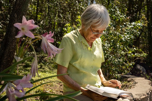 Serious mature woman reading in her garden