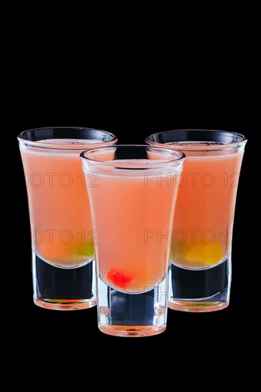 Three vodka shots with sweet jelly isolated on black background