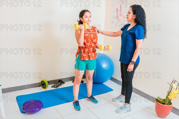 Rehabilitation physiotherapy to patient with dumbbells