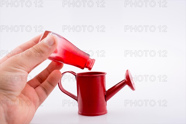 Hand holding a watering can without water on a white background