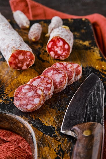 Fermented salami sausages on wooden cutting board cut on slices