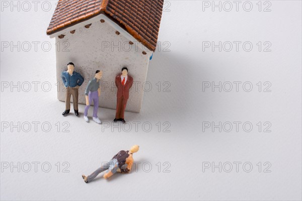 Figurine of men and poor invalid man beside house