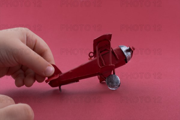 Child holding a little metal model airplane in hand