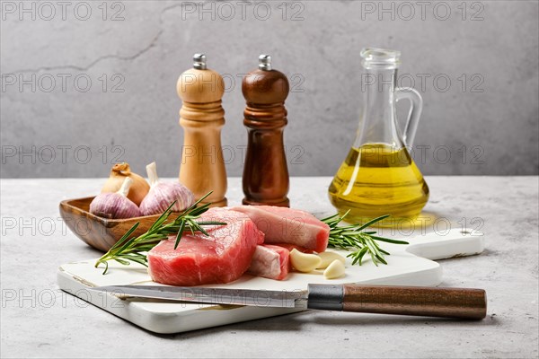 Raw fresh pork fillet cut on slices on kitchen table with spice