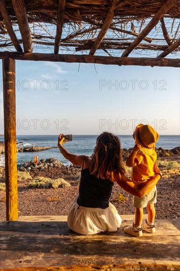 Mother and son on vacation taking a photo on Tacoron beach in El Hierro