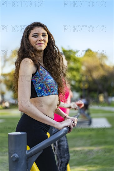 Women working out with gym playground equipment outdoors