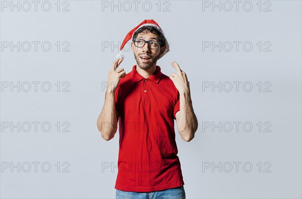 Hopeful man in christmas clothes making a wish