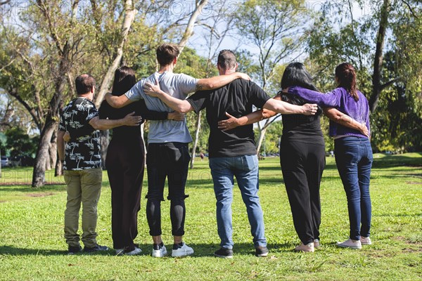 Rear view of a group of hugging friends. Friendship and support concept