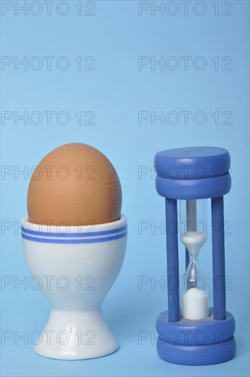 Boiled egg and hourglass on a blue background