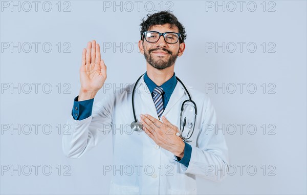 Doctor raising hand and swearing. handsome doctor making oath and promise isolated