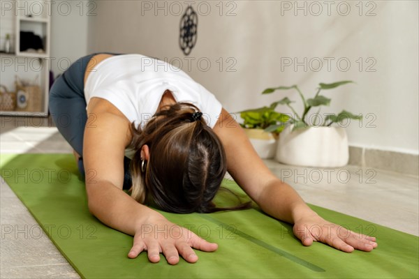 Beautiful woman practices yoga asana Balasana