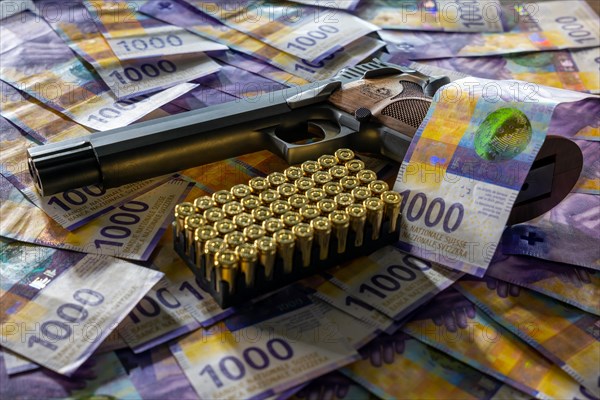 Elegant Semiautomatic 9mm Handgun with Swiss Helvetia Symbol Leaning on Swiss Franc 1000 Banknote and Bullet Ammunition in Switzerland