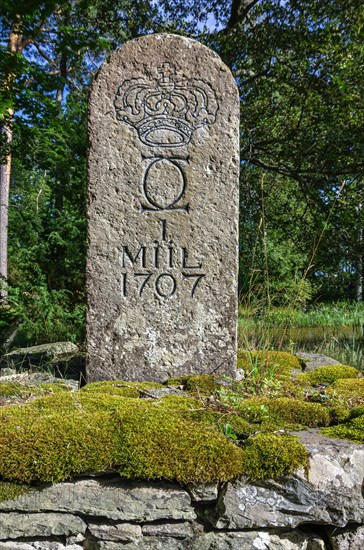 Old Swedish milestone from 1707 by the wayside in a grove in front of Laeckoe Castle by Lake Vaenern