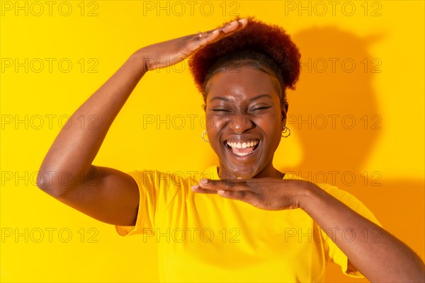 Young african american woman isolated on a yellow background smiling and dancing