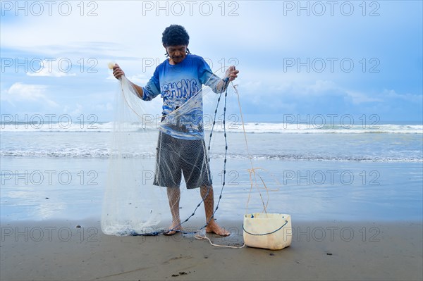 Front view of a fisherman on the shore preparing his net. Concept Lifestyle of a fisherman in the pacific sea