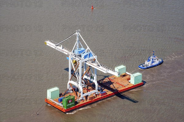 Tugboat with heavy load on a pontoon on the Elbe