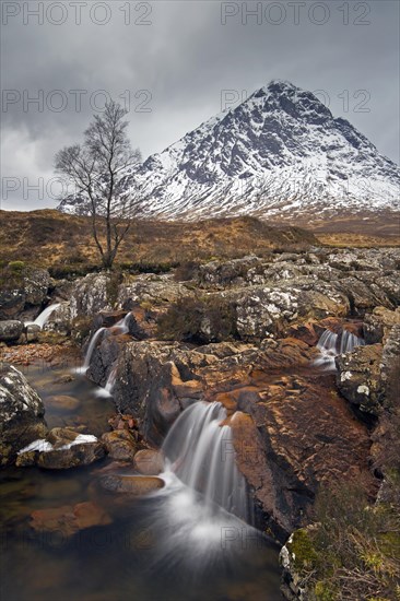 Scottish mountain Buachaille Etive Mor and waterfall on River Coupall in winter in Glen Etive near Glencoe in the Highlands of Scotland