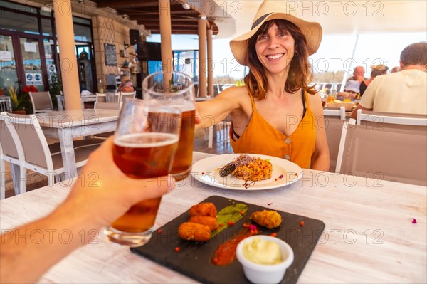 Date with girlfriend in a restaurant having dinner on the beach on vacation at sunset