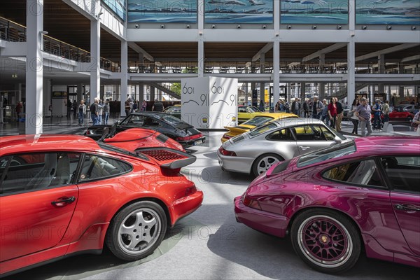 Porsche 911s lined up for presentation in an exhibition hall