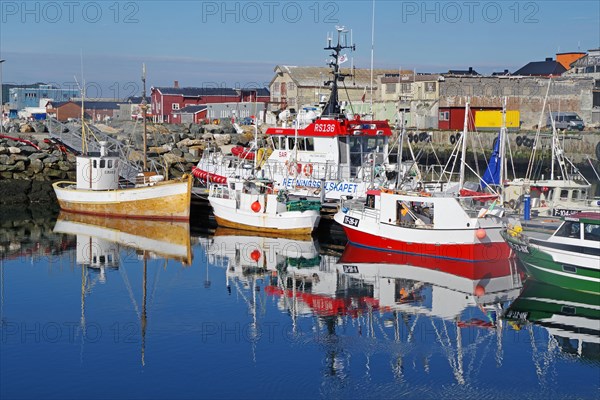 Fishing boats reflected in the smooth water of a harbour basin