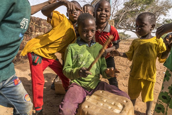 A group of African children with self-made drums singing and playing