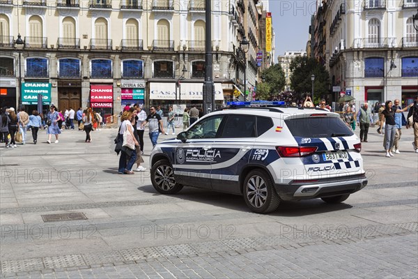 Police car and crowd in the city centre