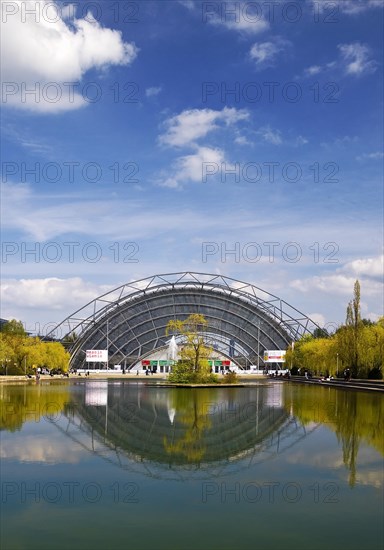 Glass hall with reflection in the water basin in front of the main entrance to the Leipzig Trade Fair