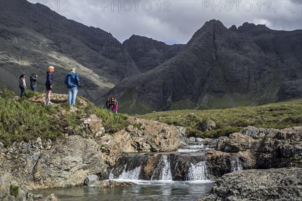 Black Cuillin and tourists visiting the Fairy Pools