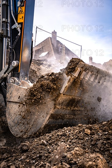 Excavator bucket of a Liebherr R922G8 with soil on construction site