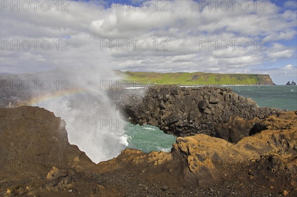 Wave crashing under natural arch