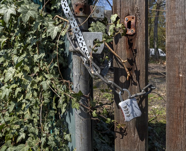 Steel chain with combination lock on wooden fence