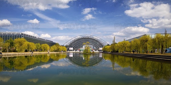 Glass hall with reflection in the water basin in front of the main entrance to the Leipzig Trade Fair